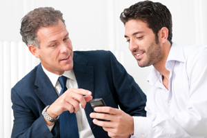 Two businessmen discussing together on a news on a smartphone